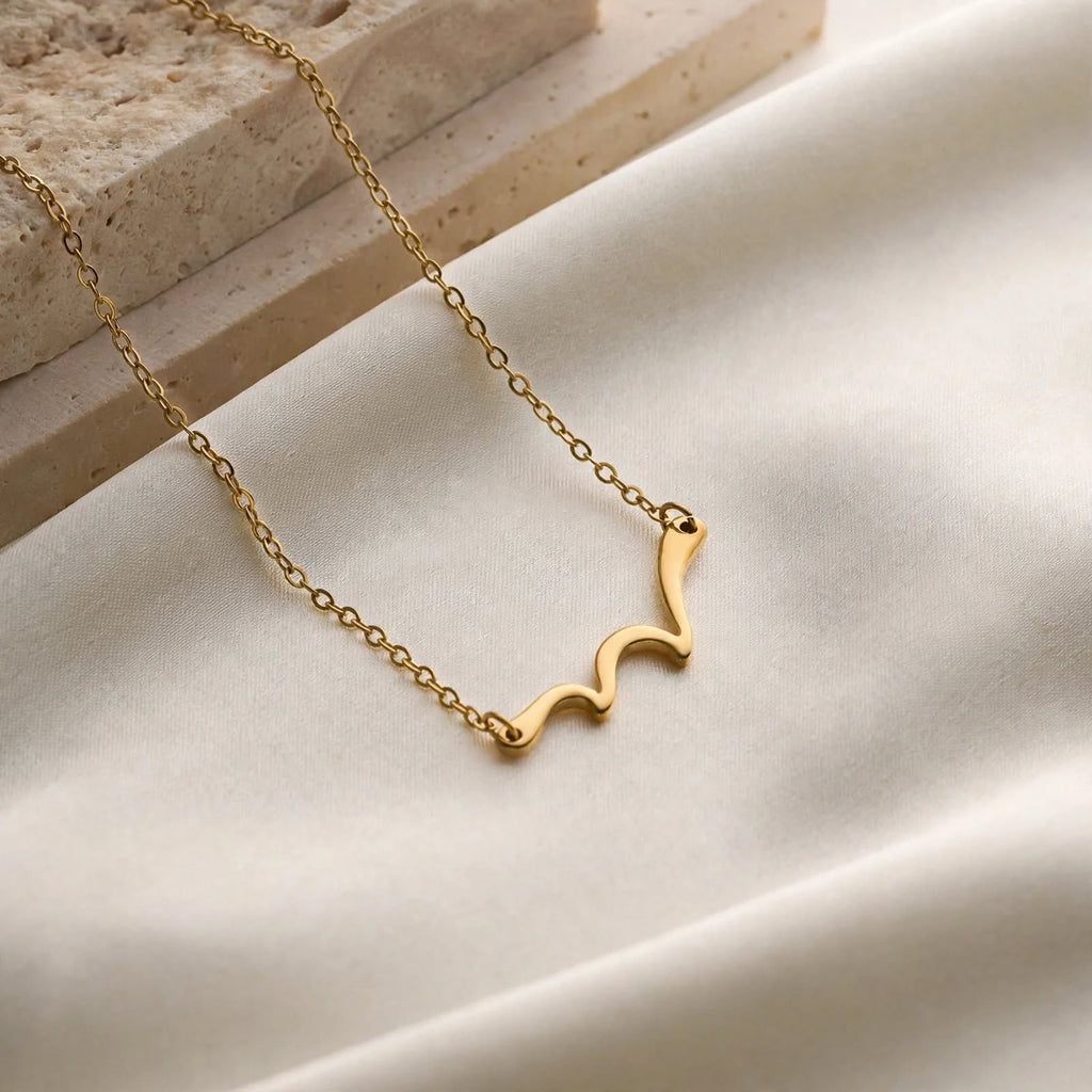 Marina Wave Pendant Necklace, gold wave pendant, on fabric